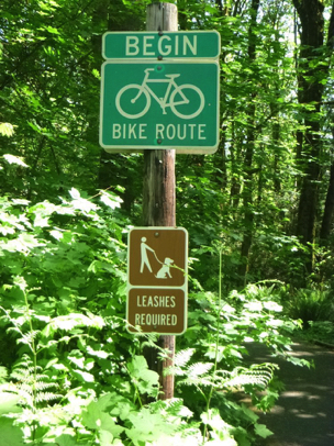 Sign: Beginning of 3 miles of paved bicycle trail – leashes are required for pets